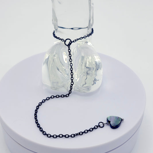 This image displays an adjustable penis chain noose paired with a shell-shaped heart, crafted in sleek black and silver colors. The chain is designed to be non-piercing, making it versatile and comfortable for wear.
