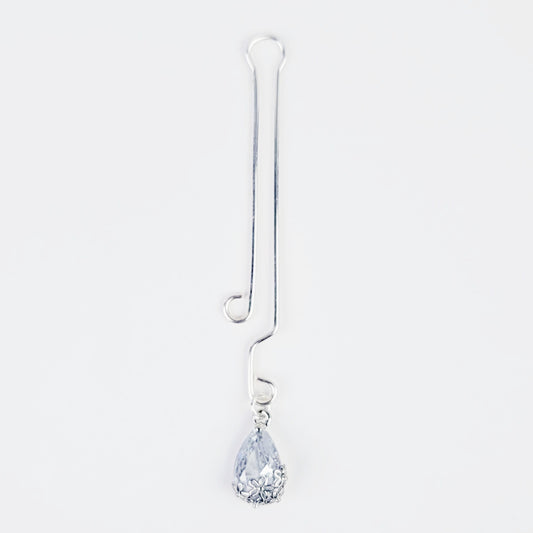 A non-piercing labia clip with a cubic zirconia pendant. The clip and pendant are silver-colored and designed for intimate use.