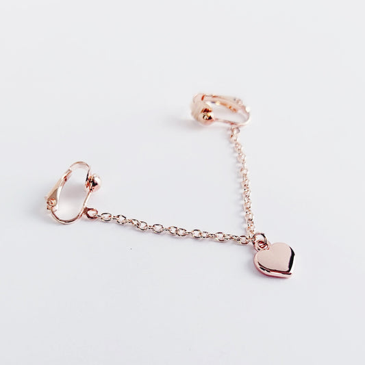 A rose gold labia chain dangle with a heart charm designed for non-piercing wear on the outer labia lips.