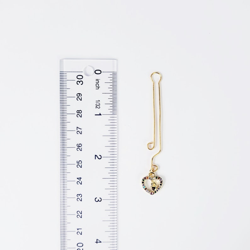 Gold Labia Clip with Gemstone Heart Next to Ruler