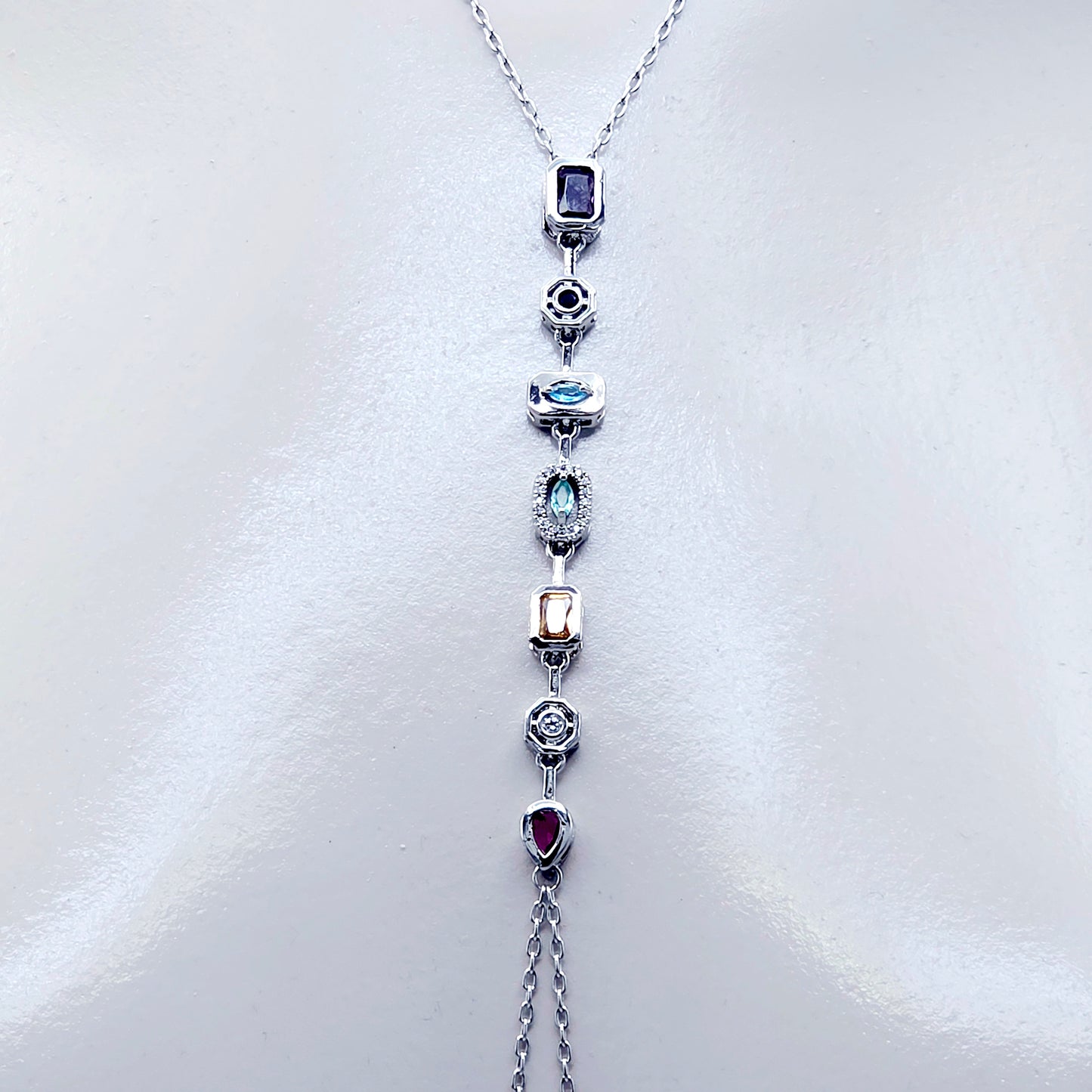 Necklace with gemstone pendants and nipple chains on a white background