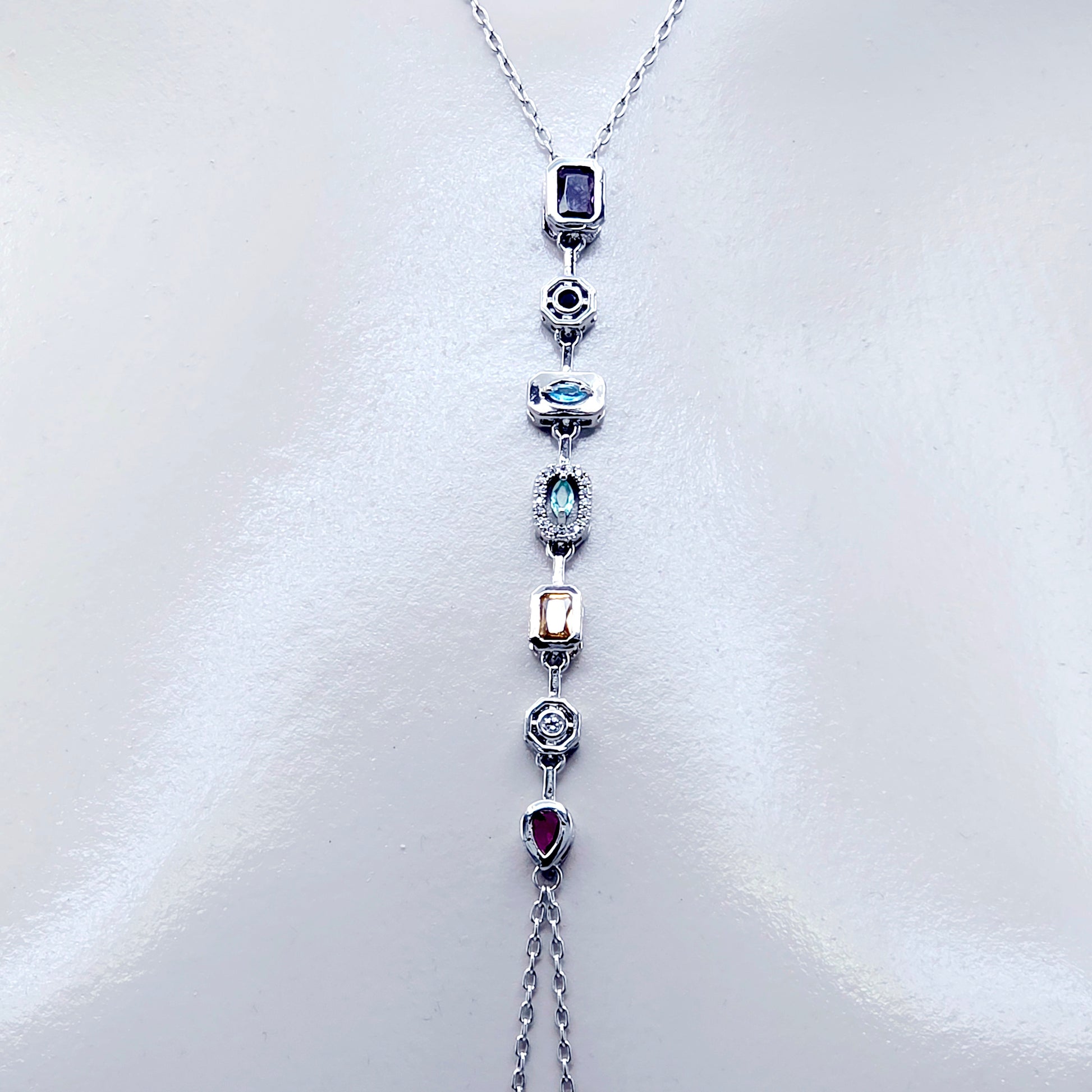 Necklace with gemstone pendants and nipple chains on a white background