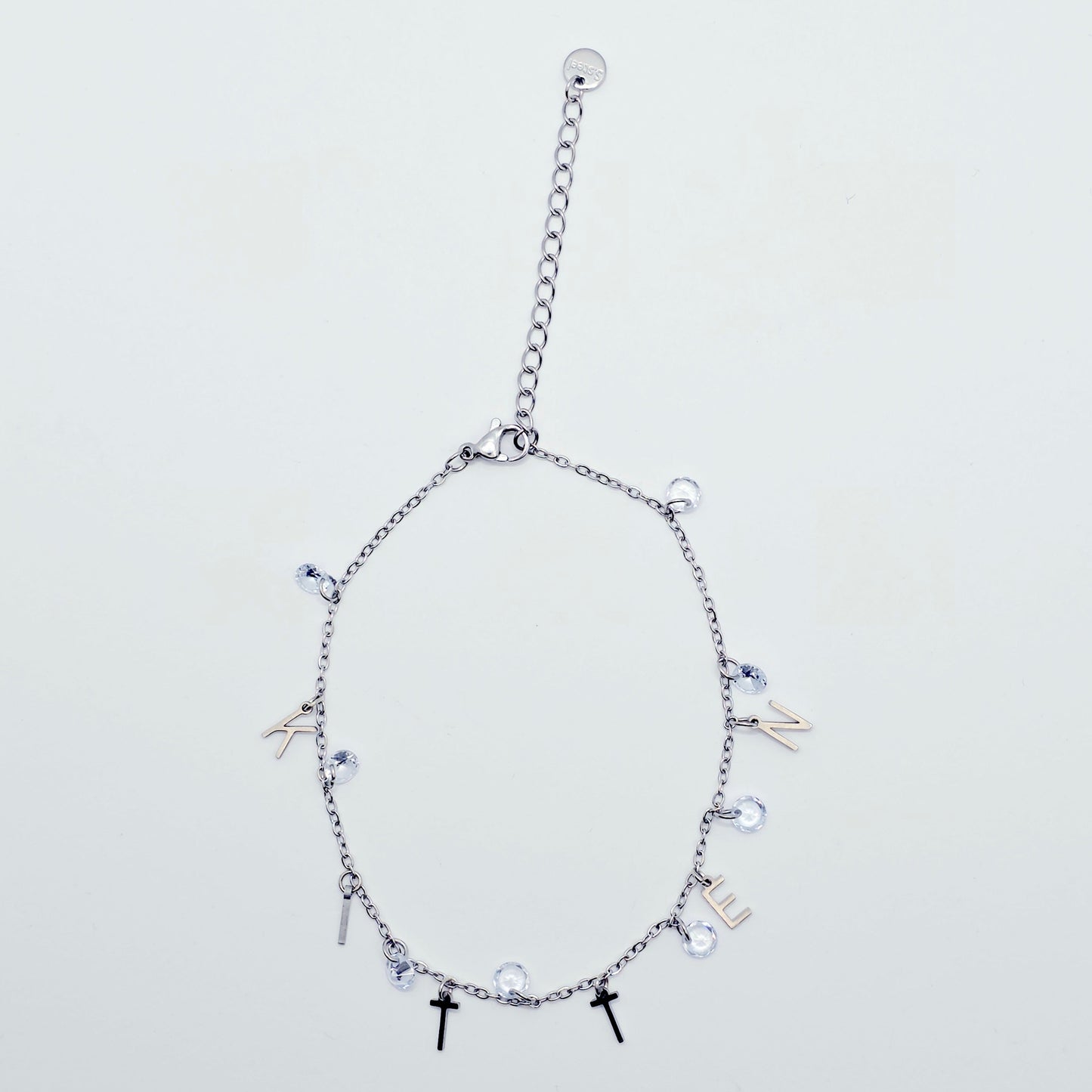 Silver bracelet with various charms on a light gray background