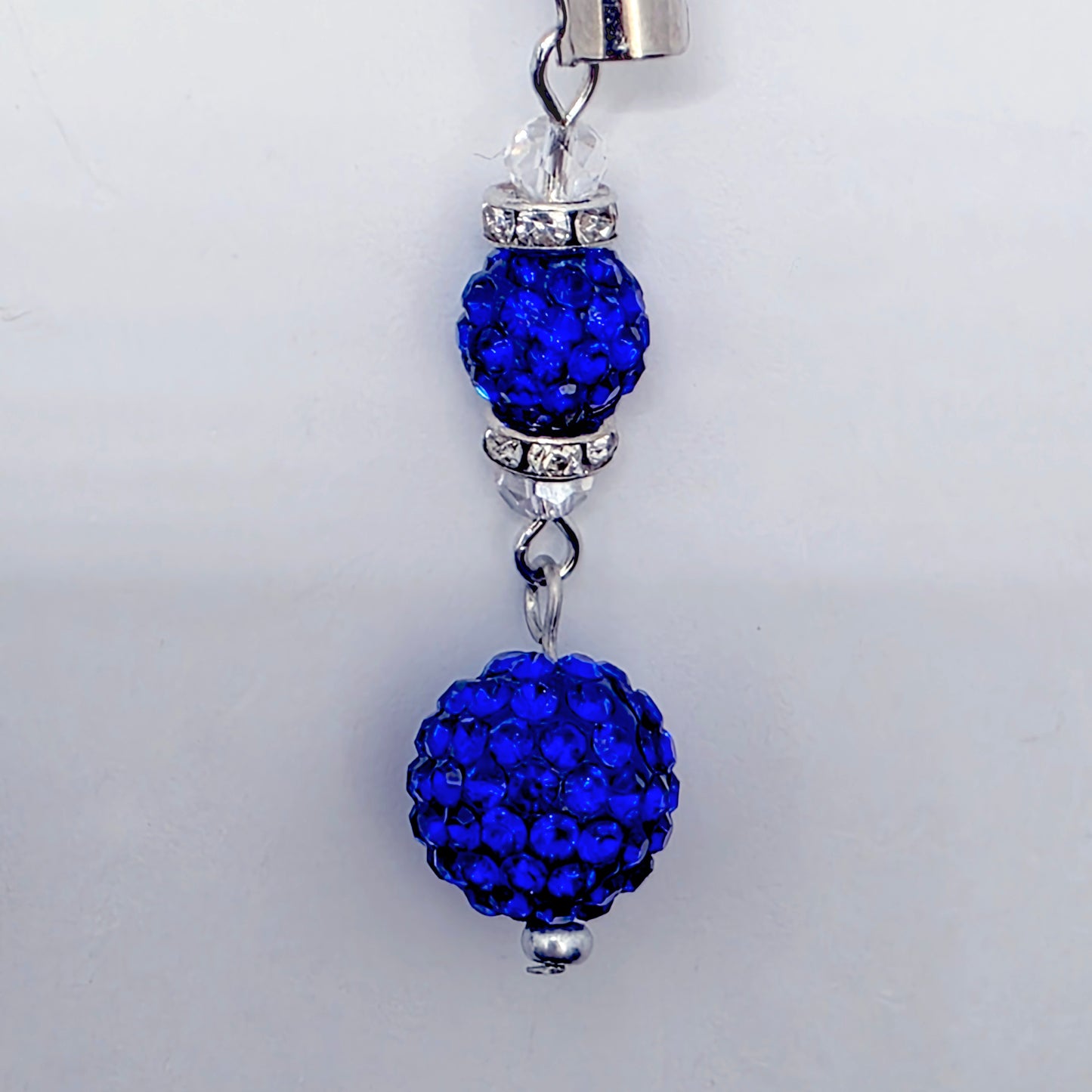 Blue beaded charm with silver accents on a white background