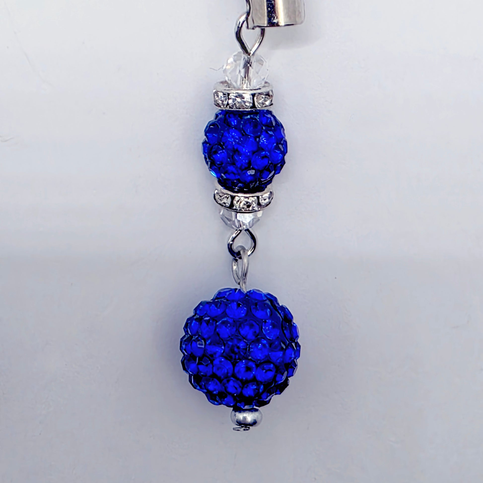Blue beaded charm with silver accents on a white background