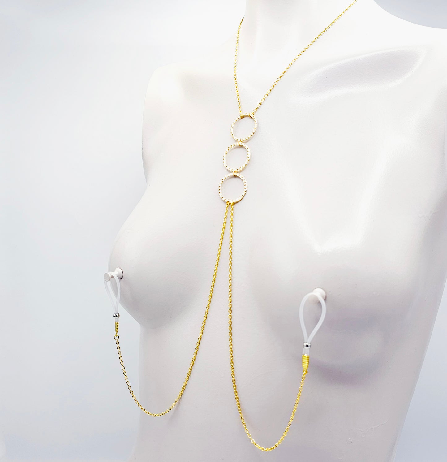 Gold Tri circle necklace attached to nipple nooses or feel the sting with one of our five types of nipple clamps.