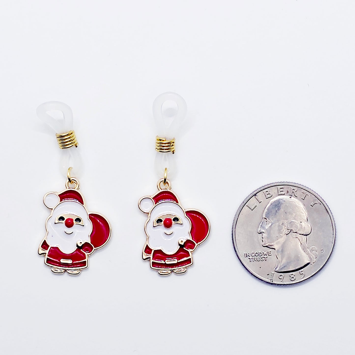 Santa Claus nipple nooses next to a quarter for size comparison on a white background