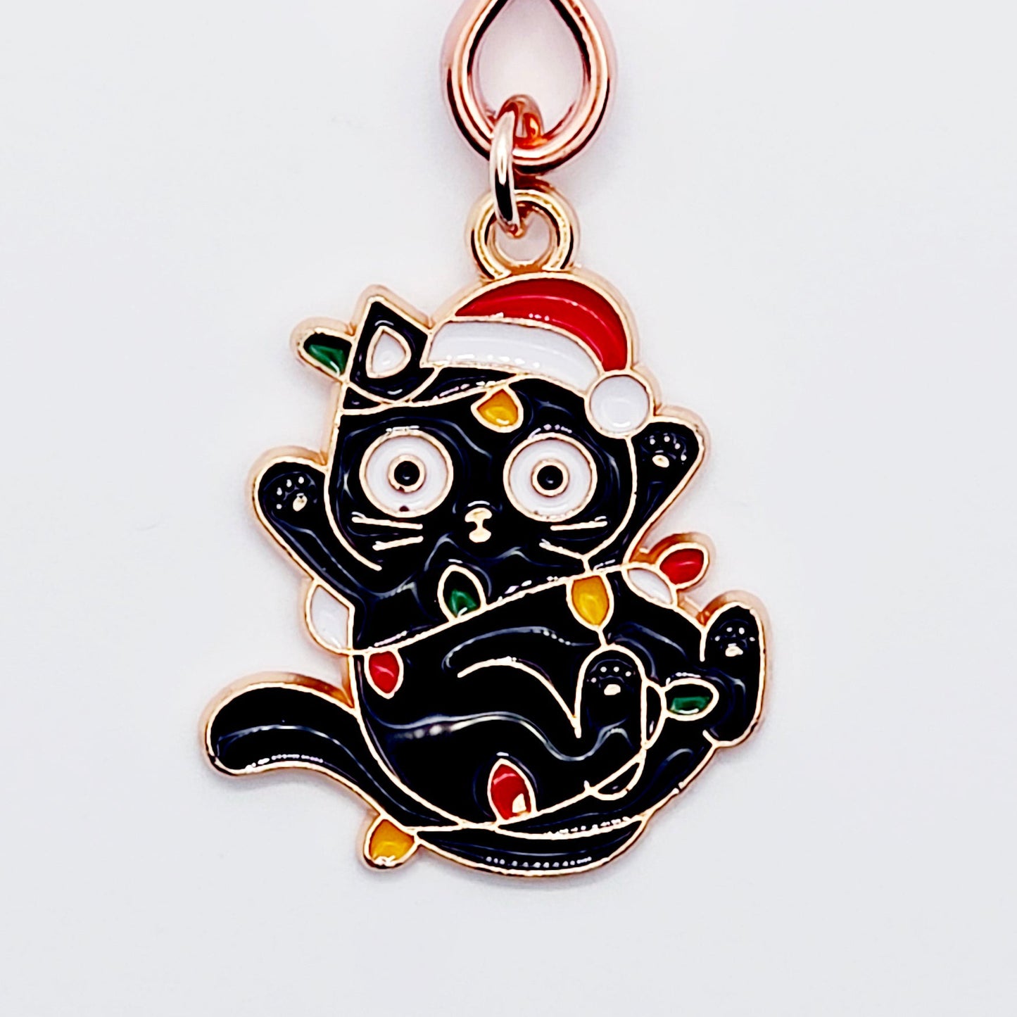 Black Kitten Wrapped in Christmas Lights wearing a Santa Hat