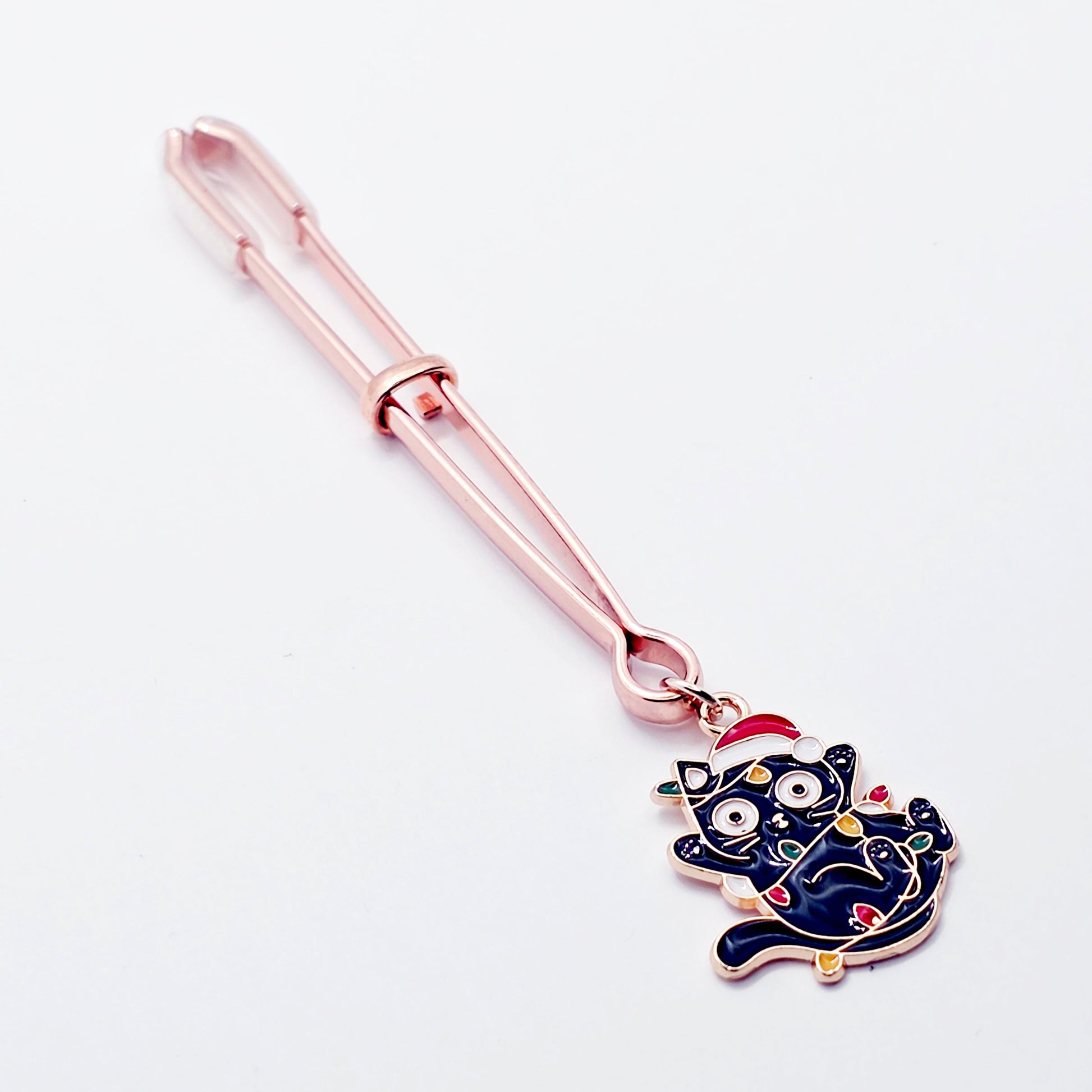 Rose Gold Tweezer Clit Clamp with Black Kitten Wrapped in Christmas Lights wearing a Santa Hat