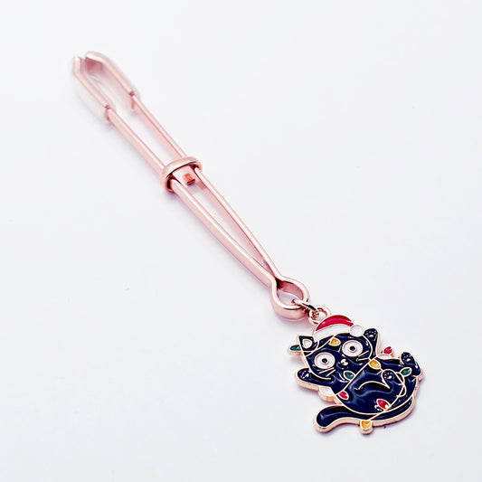 Rose Gold Tweezer Clit Clamp with Black Kitten Wrapped in Christmas Lights wearing a Santa Hat