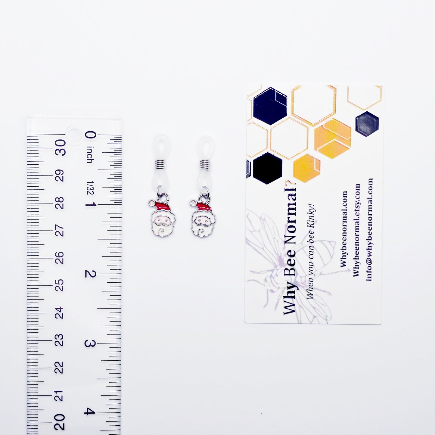 Small Nipple Nooses with a Santa Claus design next to a ruler and a business card on a white background.