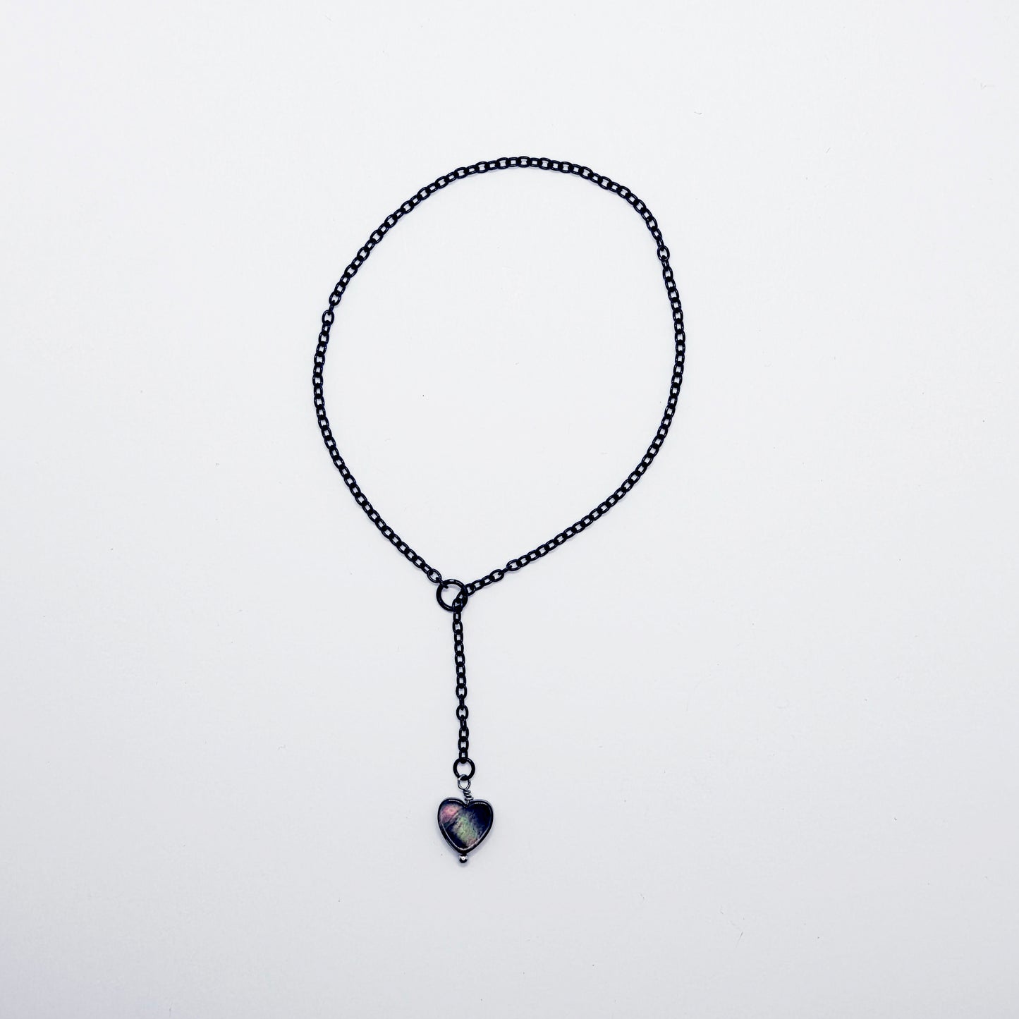 This image displays an adjustable penis chain noose paired with a shell-shaped heart, crafted in sleek black and silver colors. The chain is designed to be non-piercing, making it versatile and comfortable for wear.