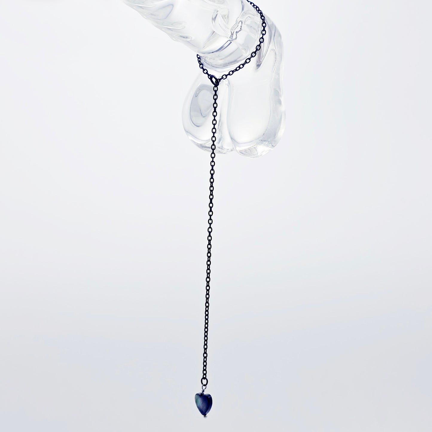 This image displays an adjustable penis chain noose paired with a shell-shaped heart, crafted in sleek black and silver colors. The chain is designed to be non-piercing, making it versatile and comfortable for wear.