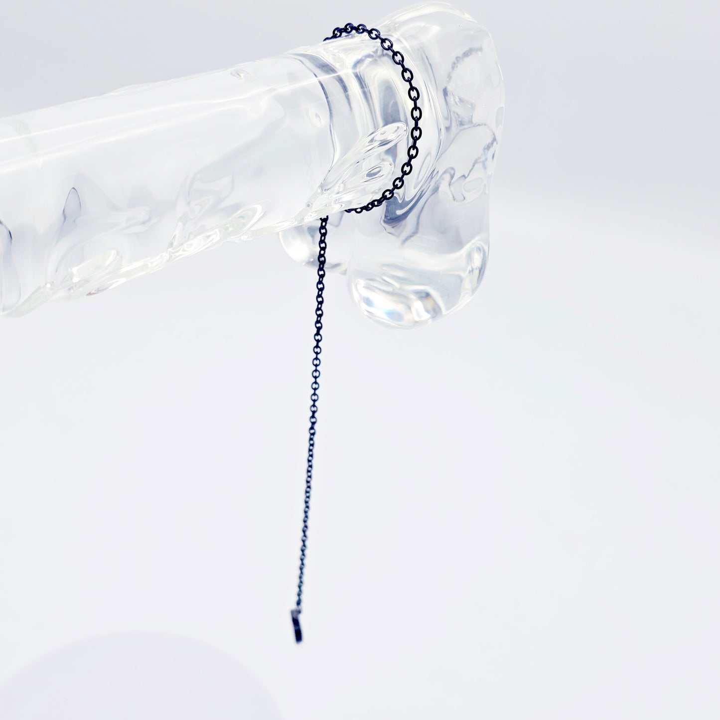 This image displays an adjustable penis chain noose paired with a shell-shaped heart, crafted in sleek black and silver colors. The chain is designed to be non-piercing, making it versatile and comfortable for wear.