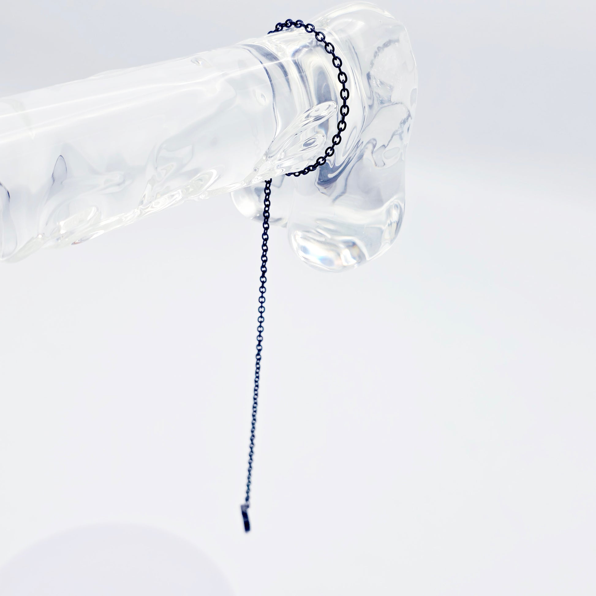 This image displays an adjustable penis chain noose paired with a shell-shaped heart, crafted in sleek black and silver colors. The chain is designed to be non-piercing, making it versatile and comfortable for wear.